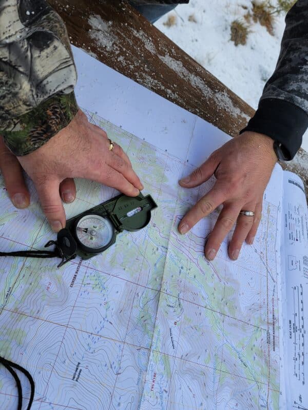 Hands with a compass on a topographic map